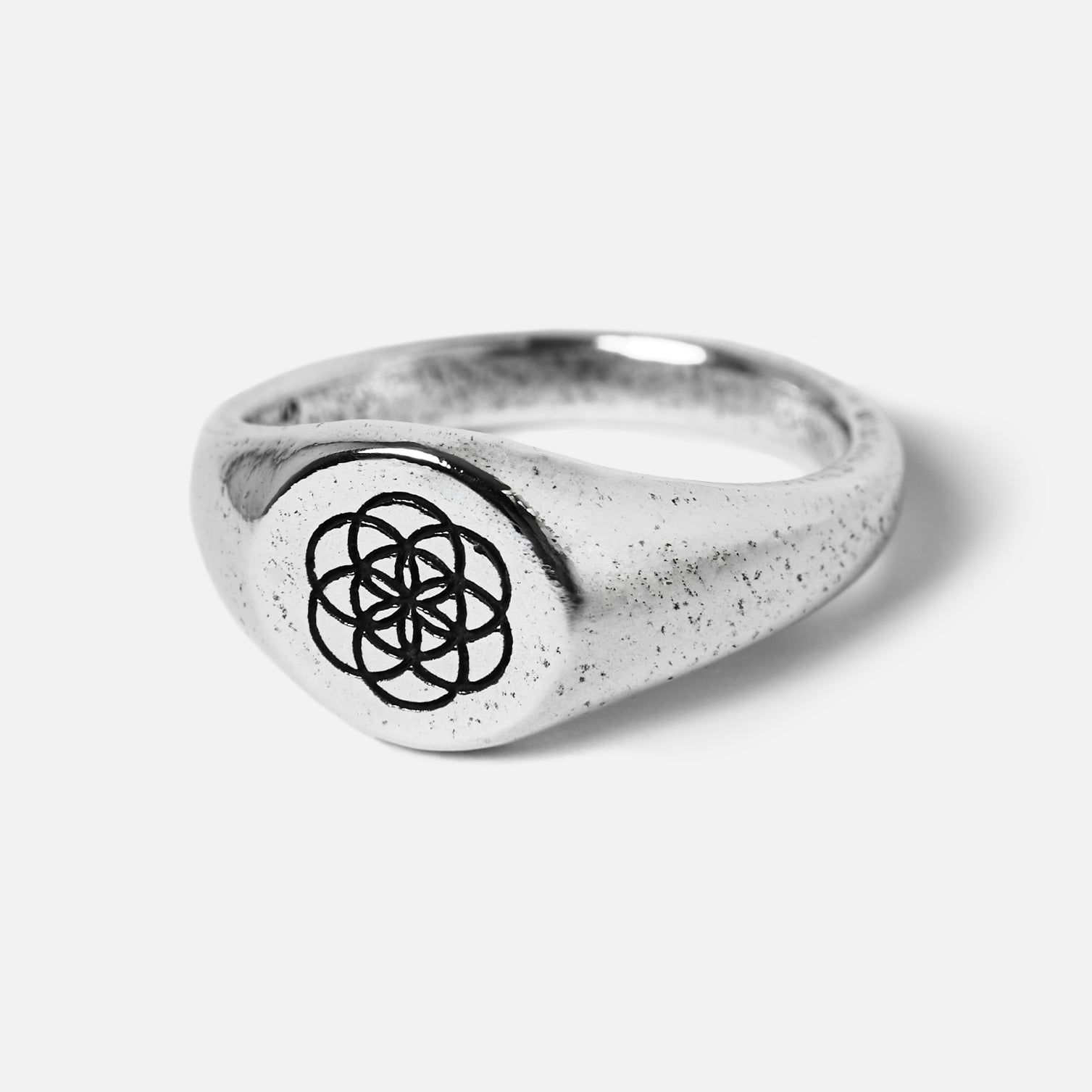 Silver ring with a black symbol on a white background