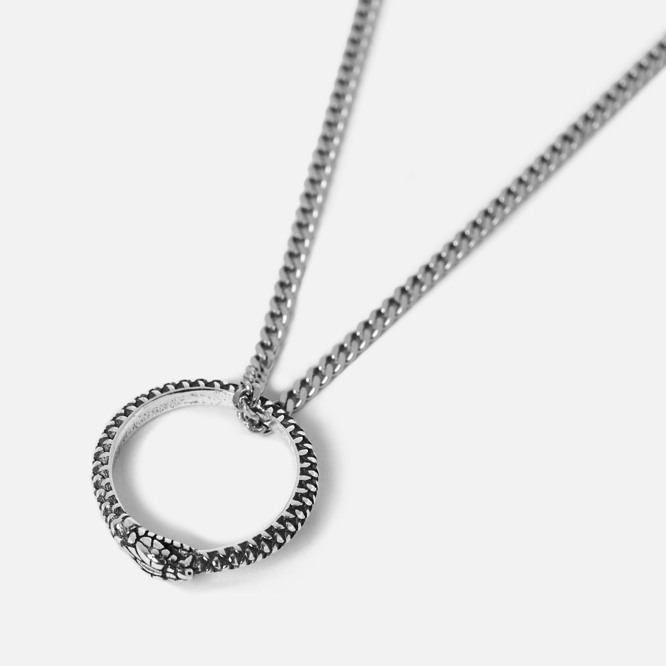 Silver snake necklace with a circular pendant on a light grey background